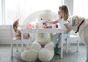 A little girl having a pretend tea party.