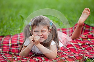 Little irritated girl preschooler lying on plaid
