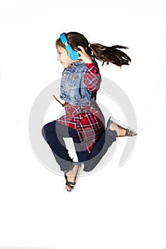 Little jumping caucasian girl with a headphones