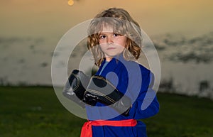 Little karate fighter. Kid boy practicing karate outdoor. Sport karate kids fighter. Little boy wearing kimono doing