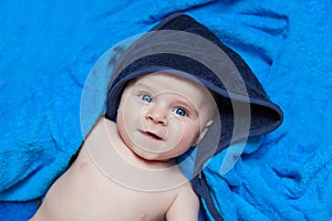 Little kid baby boy against blue bath towel