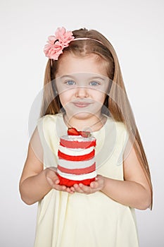 Little kid blonde girl holding a red velvet cake