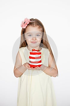 Little kid blonde girl holding a red velvet cake