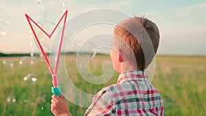 little kid blowing bubbles on green field, child holiday holiday, children fantasy dreams, happy family, cheerful boy