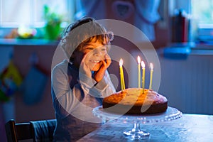little kid boy celebrating his birthday with cake and candles
