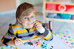 Little kid boy drawing with colorful watercolors