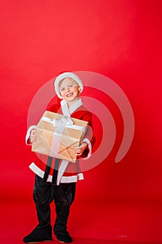 Little kid boy dressed as Santa Claus. Christmas shopping. Christmas present. Childhood. New Year party. Santa Claus baby