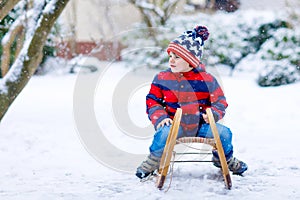 Little kid boy enjoying sleigh ride in winter