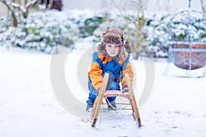 Little kid boy enjoying sleigh ride in winter