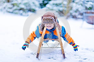 Little kid boy enjoying sleigh ride in winter