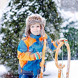 Little kid boy enjoying sleigh ride in winter