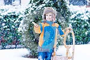 Little kid boy enjoying sleigh ride in winter