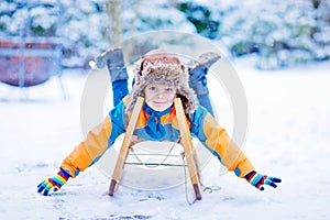 Little kid boy enjoying sleigh ride in winter