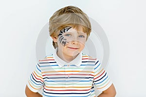 Little kid boy with face painted with a spider web