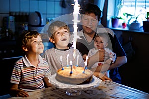 Little kid boy and family, father, brother and baby sister celebrating birthday