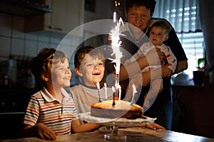 Little kid boy and family, father, brother and baby sister celebrating birthday