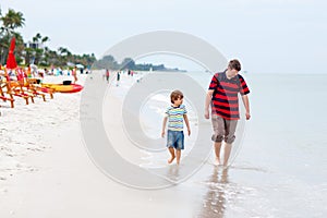 Little kid boy and father having fun with collecting shells