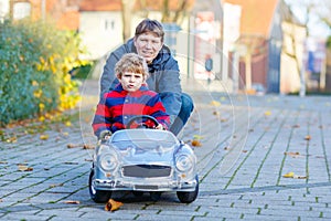 Little kid boy and father playing with car, outdoors
