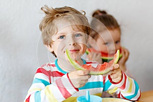 Little kid boy and girl eating healthy food watermelon