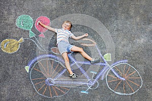 Little kid boy having fun with bike chalks picture