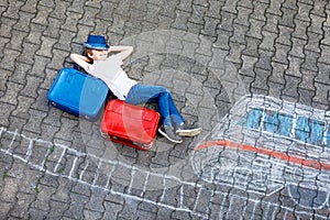 Little kid boy having fun with fast train picture drawing with colorful chalks on asphalt