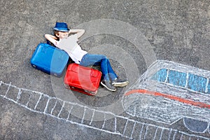 Little kid boy having fun with fast train picture drawing with colorful chalks on asphalt