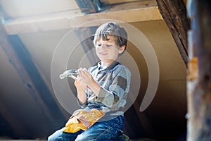 Little kid boy helping with toy tools on construciton site.