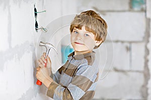 Little kid boy helping with toy tools on construciton site. Funny child of 6 years having fun on building new family