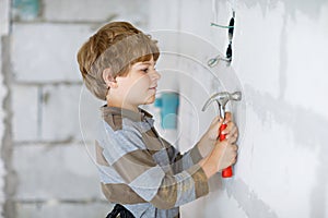 Little kid boy helping with toy tools on construction site. Funny child of 6 years having fun on building new family