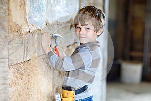 Little kid boy helping with toy tools on construction site. Funny child of 6 years having fun on building new family