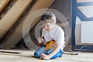 Little kid boy helping with toy tools on construction site. Funny child of 6 years having fun on building new family