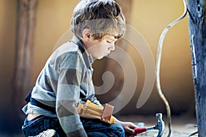 Little kid boy helping with toy tools on construction site. Funny child of 6 years having fun on building new family