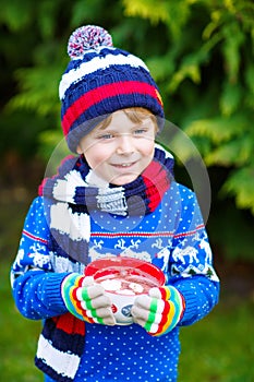 Little kid boy holding big cup with chocolate drink