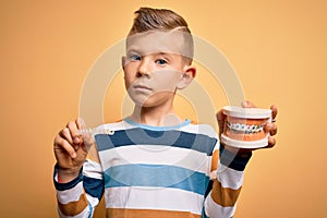 Little kid boy holding professional orthodontic denture with metal braces and removable invisible aligner