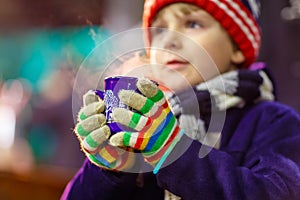 Little kid boy with hot chocolate on Christmas market