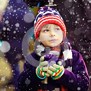 Little kid boy with hot chocolate on Christmas market