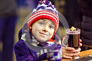 Little kid boy with hot chocolate on Christmas market