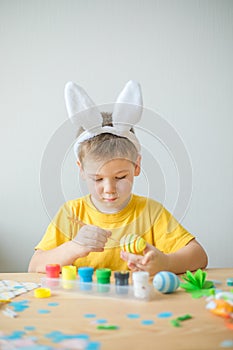 Little kid boy painted  easter egg. DIY  for easter holidays with kids.  Craft for spring