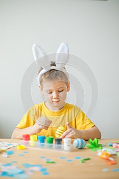 Little kid boy painted  easter egg. DIY  for easter holidays with kids.  Craft for spring