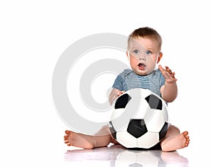 Little kid boy playing a new soccer ball on a white background.