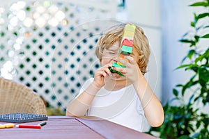 Little kid boy playing with plastic blocks