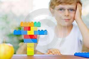 Little kid boy playing with plastic blocks