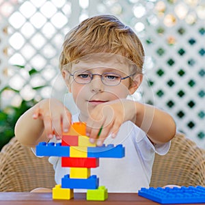 Little kid boy playing with plastic blocks
