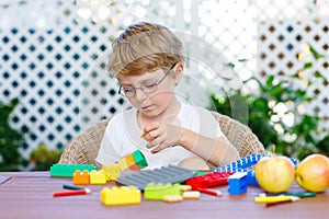 Little kid boy playing with plastic blocks