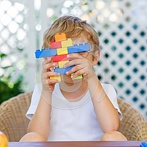 Little kid boy playing with plastic blocks