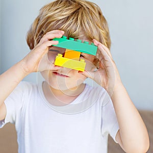 Little kid boy playing with plastic blocks