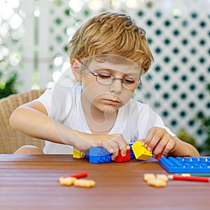 Little kid boy playing with plastic blocks