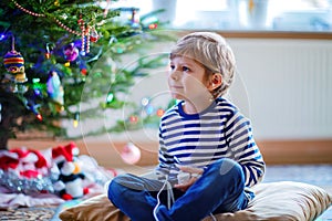 Little kid boy playing video game console on Christmas