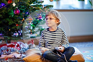 Little kid boy playing video game console on Christmas