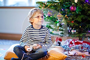 Little kid boy playing video game console on Christmas